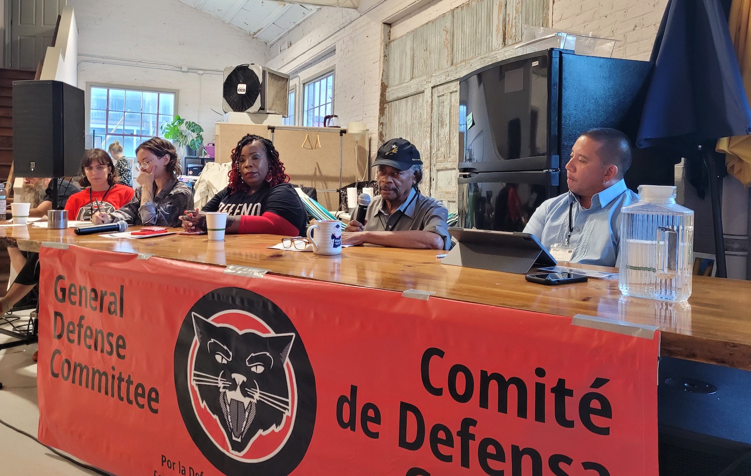 4 people sit behind a table in preparation to speak at the opening panel of the GDC anti-capitalist conference 2023.