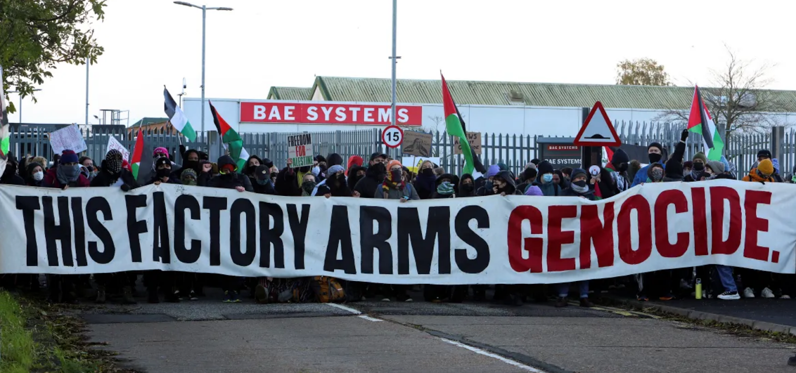 protest against BAE systems with banner "this factory arms genocide"